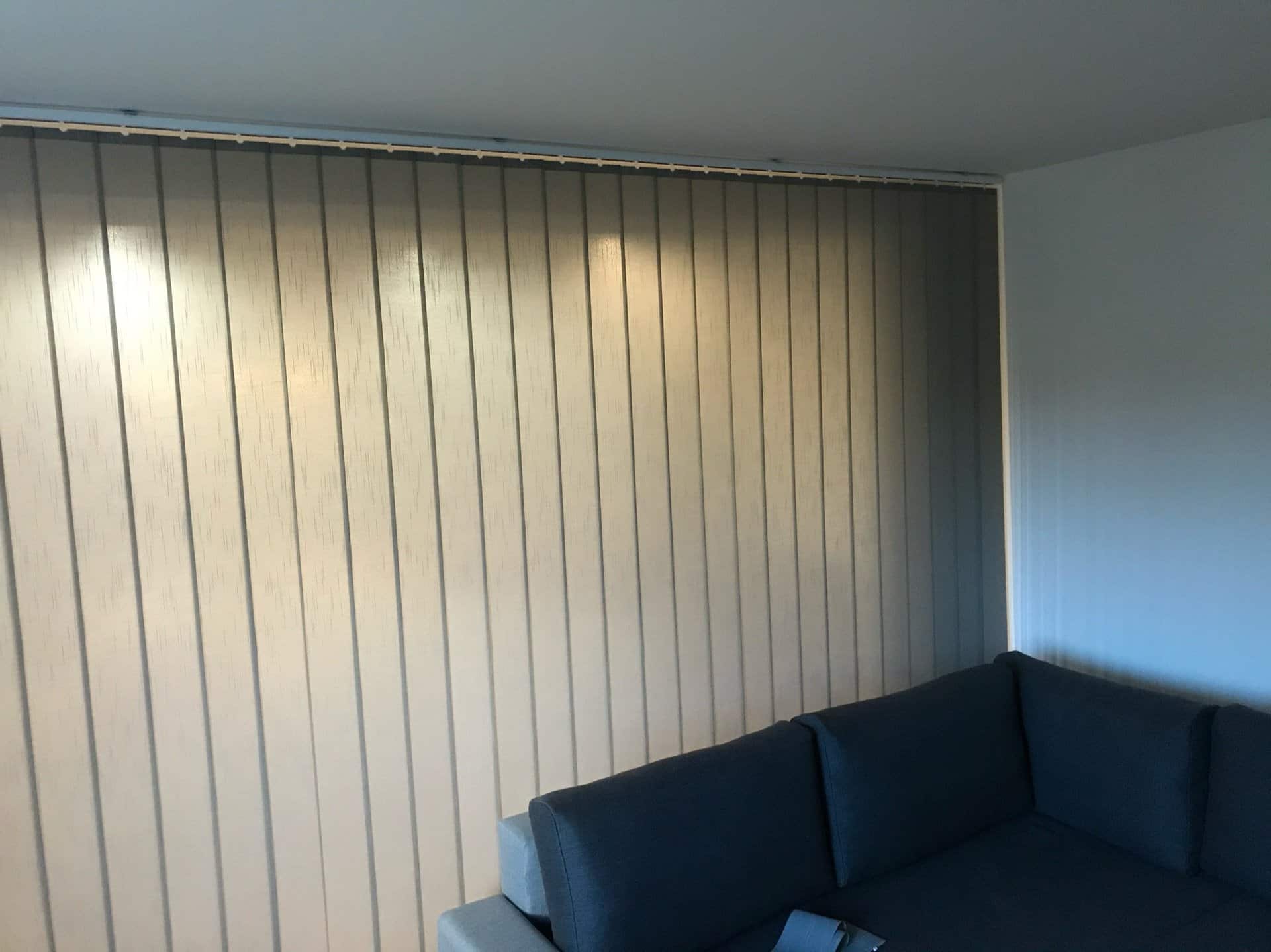 Vertikálne žalúzie oddeľujúce spánkovú zónu od obývacej časti v byte 1+kk